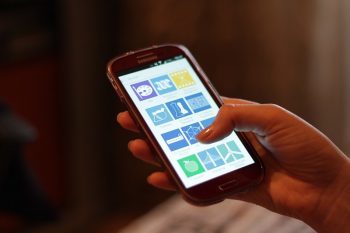 Person holding a smartphone in their hand and scrolling.