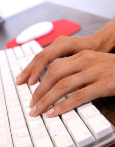 two hands resting on a computer keyboard
