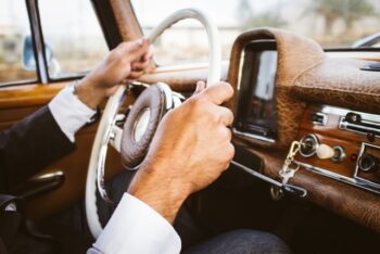 man driving a vintage car after wrist surgery